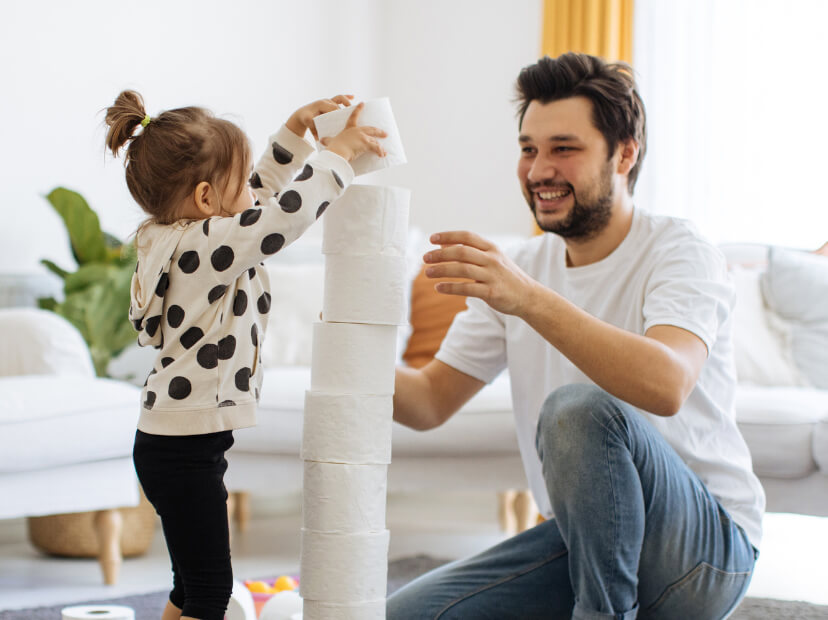 Father and daughter playing with tissue