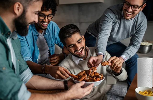 A group of friends enjoying a plate of Chicken Wings