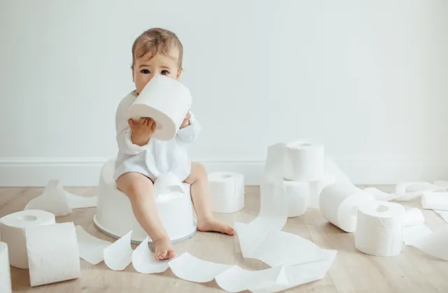 Baby with toilet paper rolls