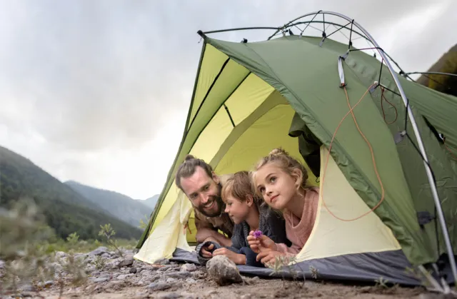 A father with his two children in a tent